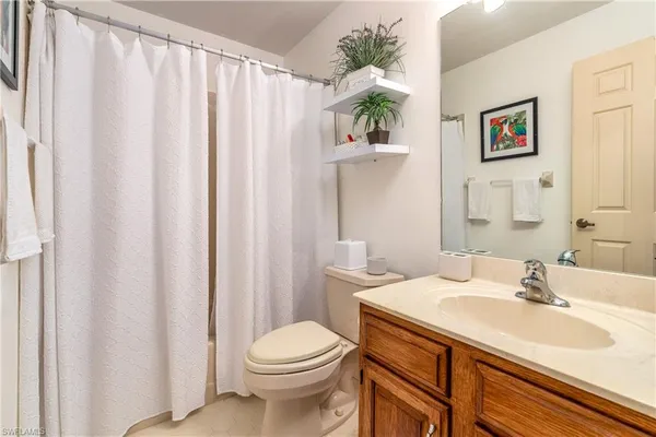 a bathroom with a sink a toilet and shower curtain
