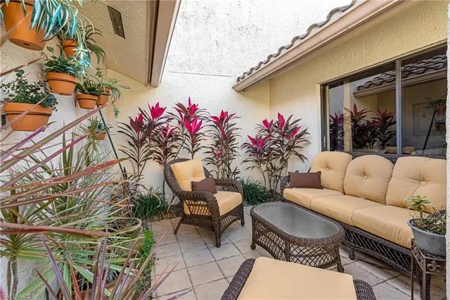 a view of a patio with couches table and chairs and potted plants
