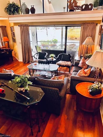 a living room with furniture fireplace and a large window