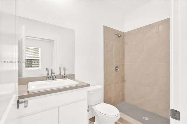 a bathroom with a sink a toilet a mirror and shower