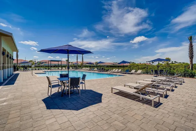 a roof deck with table and chairs under an umbrella with a barbeque