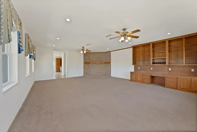 an empty room with chandelier and windows