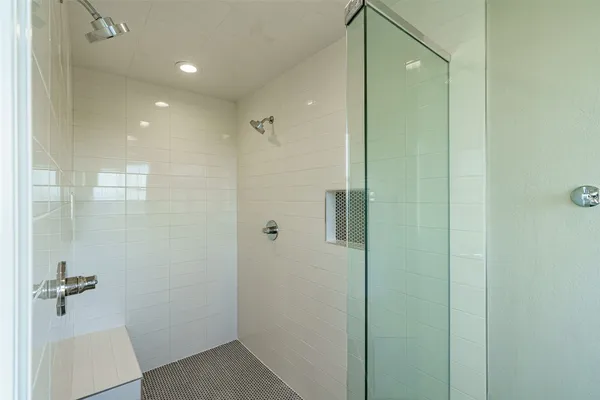 a bathroom with a shower and a glass door