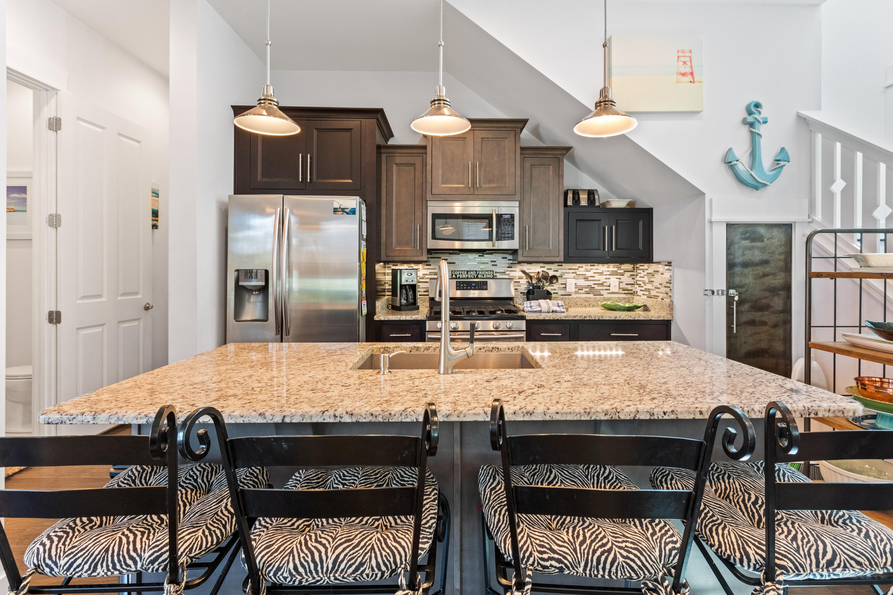 18 Hiker Street Santa Rosa Beach, FL 32459 - Photo 11 of 39 a kitchen with stainless steel appliances granite countertop a stove a refrigerator a sink a dining table and chairs with wooden floor