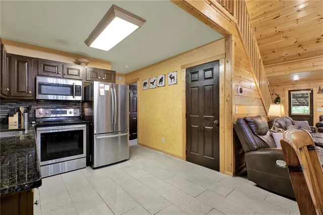 a kitchen with stainless steel appliances granite countertop sink microwave and wooden cabinets