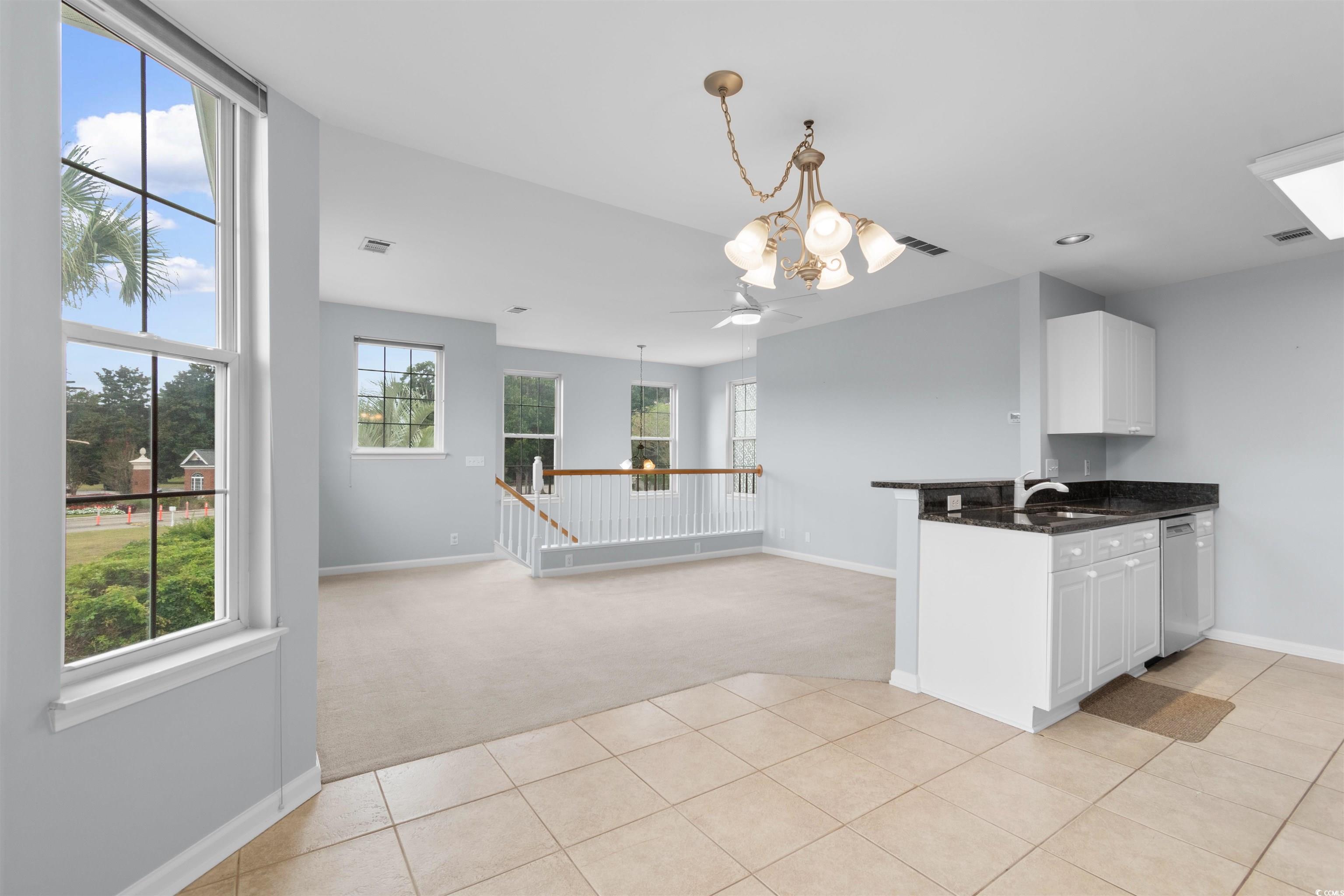 4430 Lady Banks Lane, Unit A2 Murrells Inlet, SC 29576 - Photo 13 of 31 Kitchen with light colored carpet, white cabinetry, light tile patterned flooring, a chandelier, and a peninsula