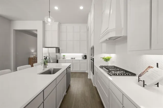 a kitchen with granite countertop white cabinets and stainless steel appliances