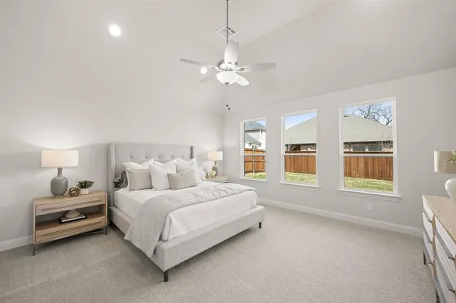 a spacious bedroom with a bed and a chandelier