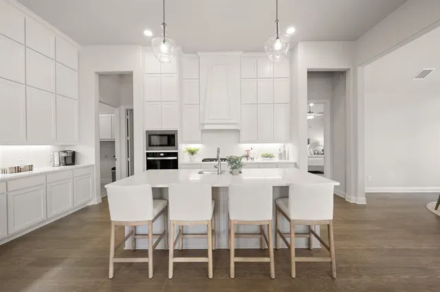 a kitchen with white cabinets and stainless steel appliances