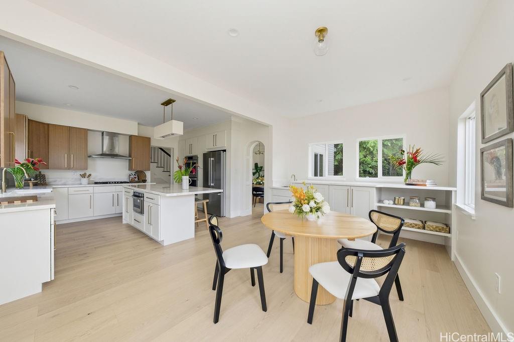 3198 Alika Avenue Honolulu, HI 96817 - Photo 6 of 25 a kitchen with a dining table chairs and white cabinets