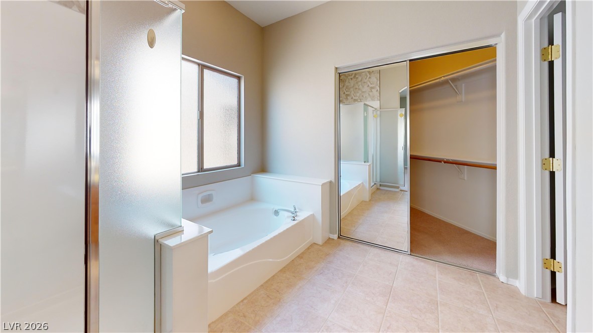 3591 Driving Range Street Las Vegas, NV 89122 - Photo 64 of 79 This primary bathroom features a comfortable soaking tub and a spacious walk-in closet for ample storage.