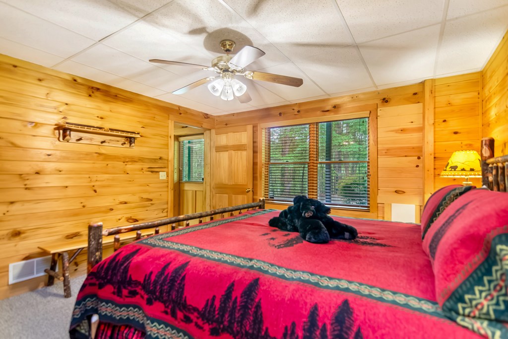4834 Squirrel Hunting Road Morganton, GA 30560 - Photo 17 of 48 a bedroom with a bed a chandelier and a large window