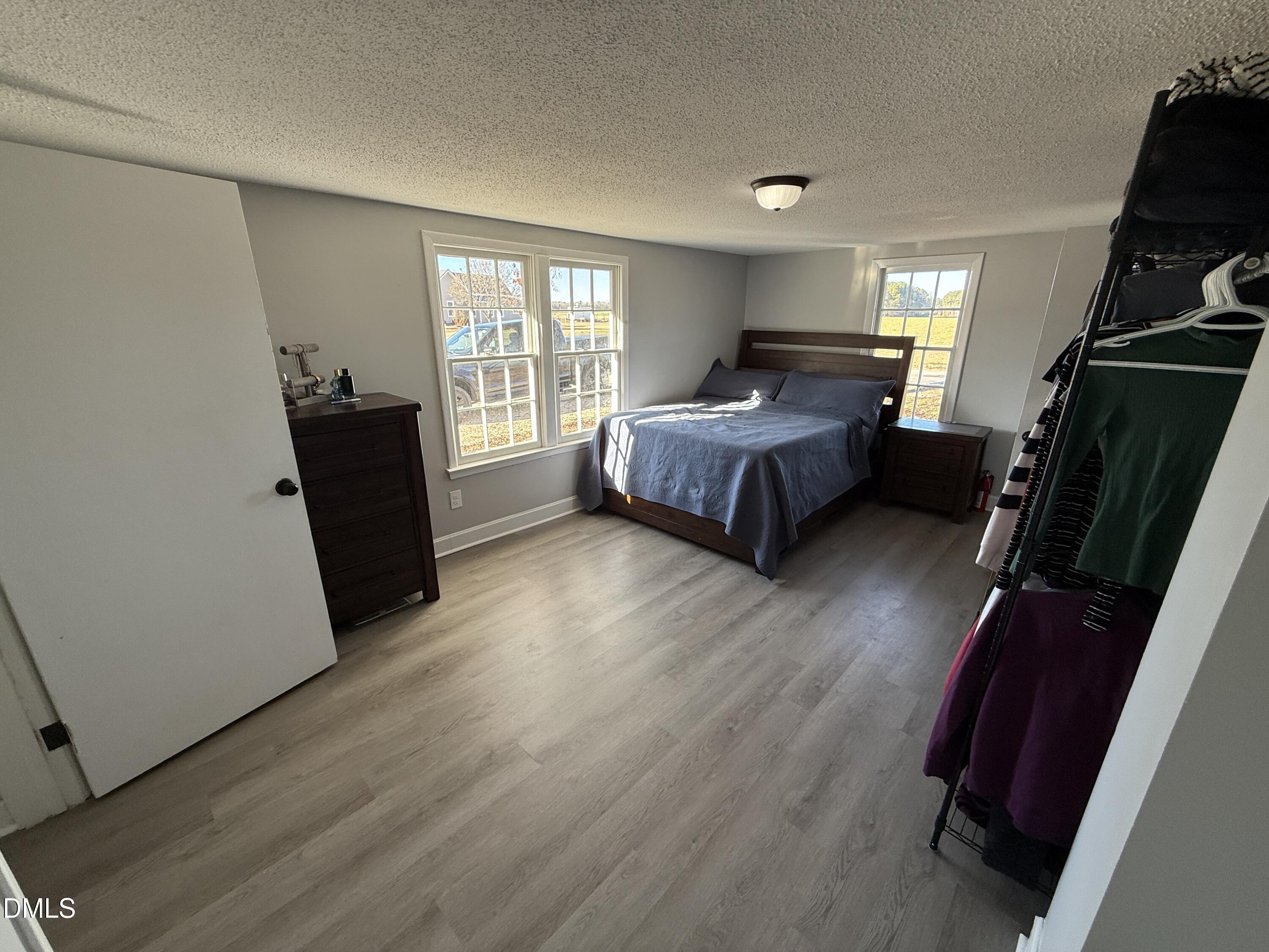 895 Stewart Road Four Oaks, NC 27524 - Photo 15 of 38 a bedroom with a bed and wooden floor