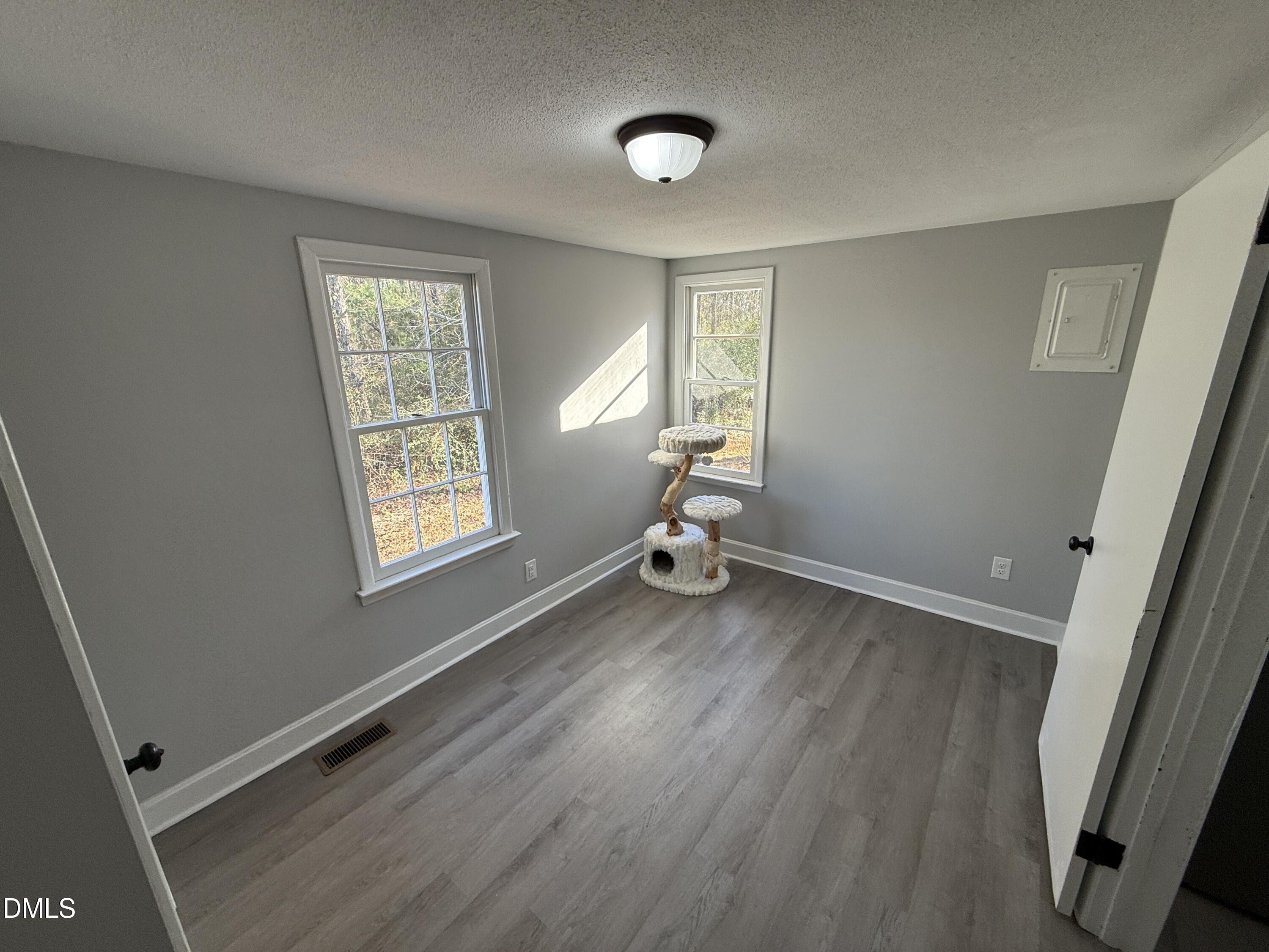 895 Stewart Road Four Oaks, NC 27524 - Photo 20 of 38 a view of a room with wooden floor and windows