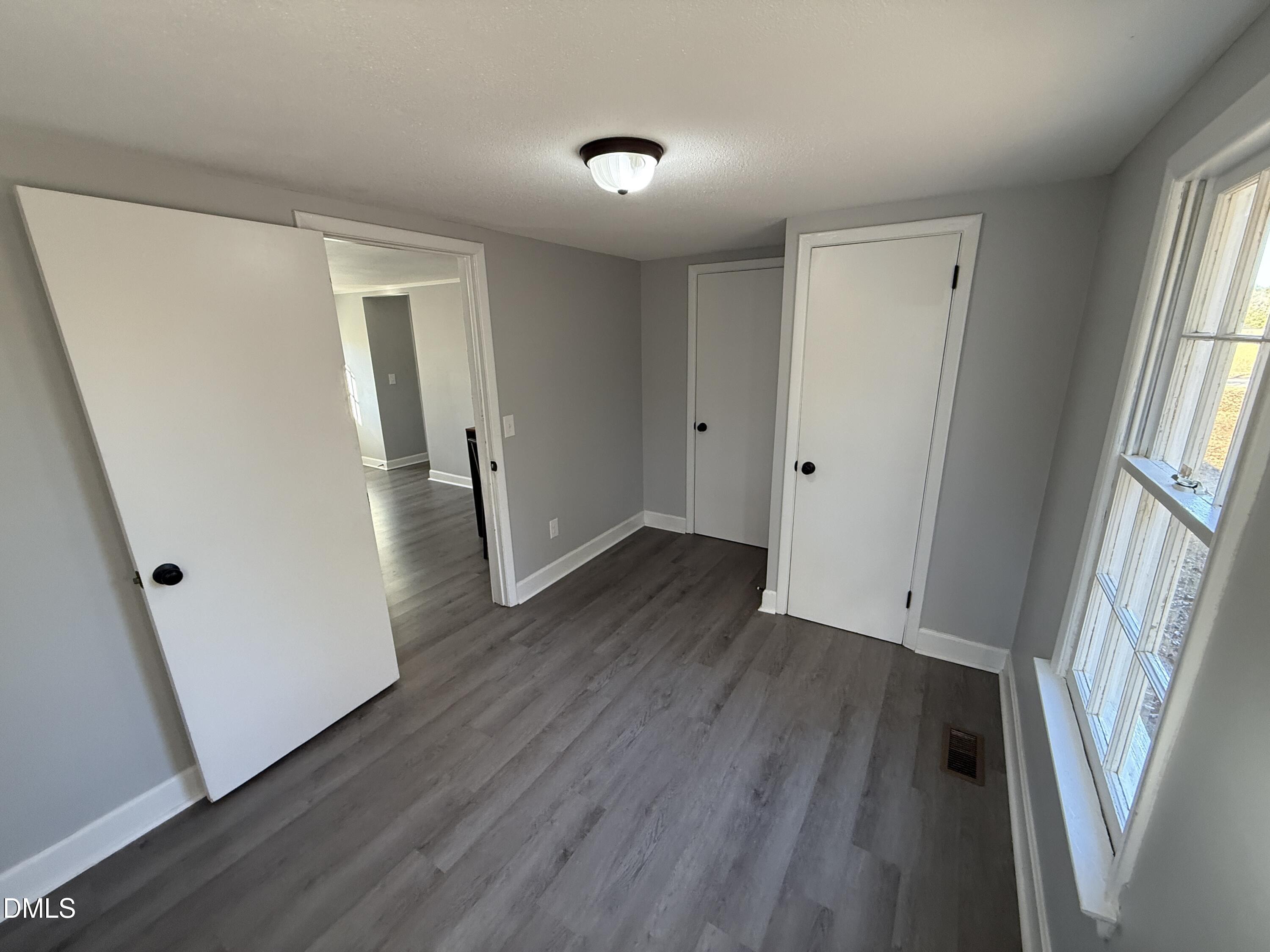 895 Stewart Road Four Oaks, NC 27524 - Photo 23 of 38 wooden floor in an empty room with a window