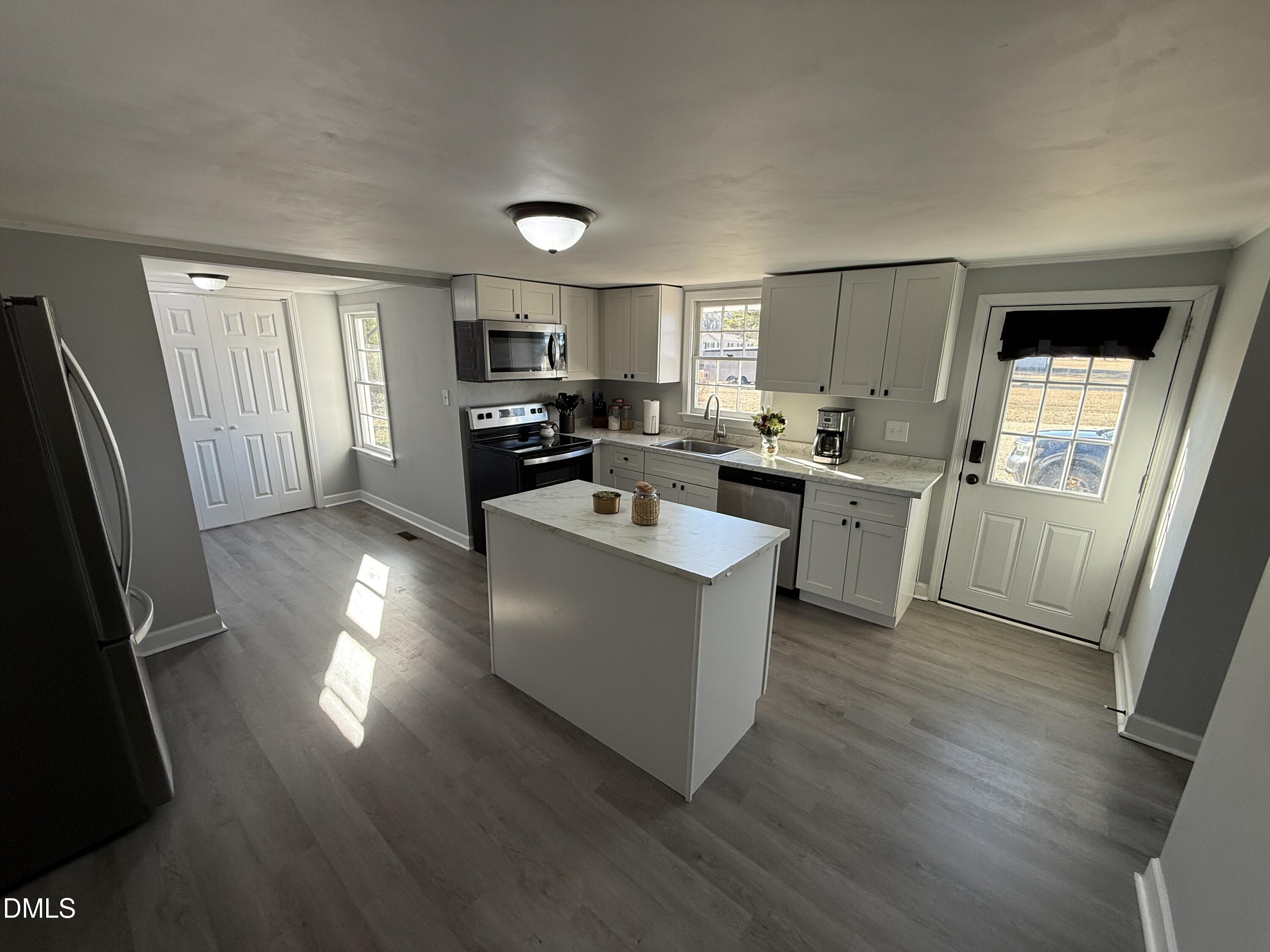 895 Stewart Road Four Oaks, NC 27524 - Photo 6 of 38 a living room with furniture a large window and wooden floor