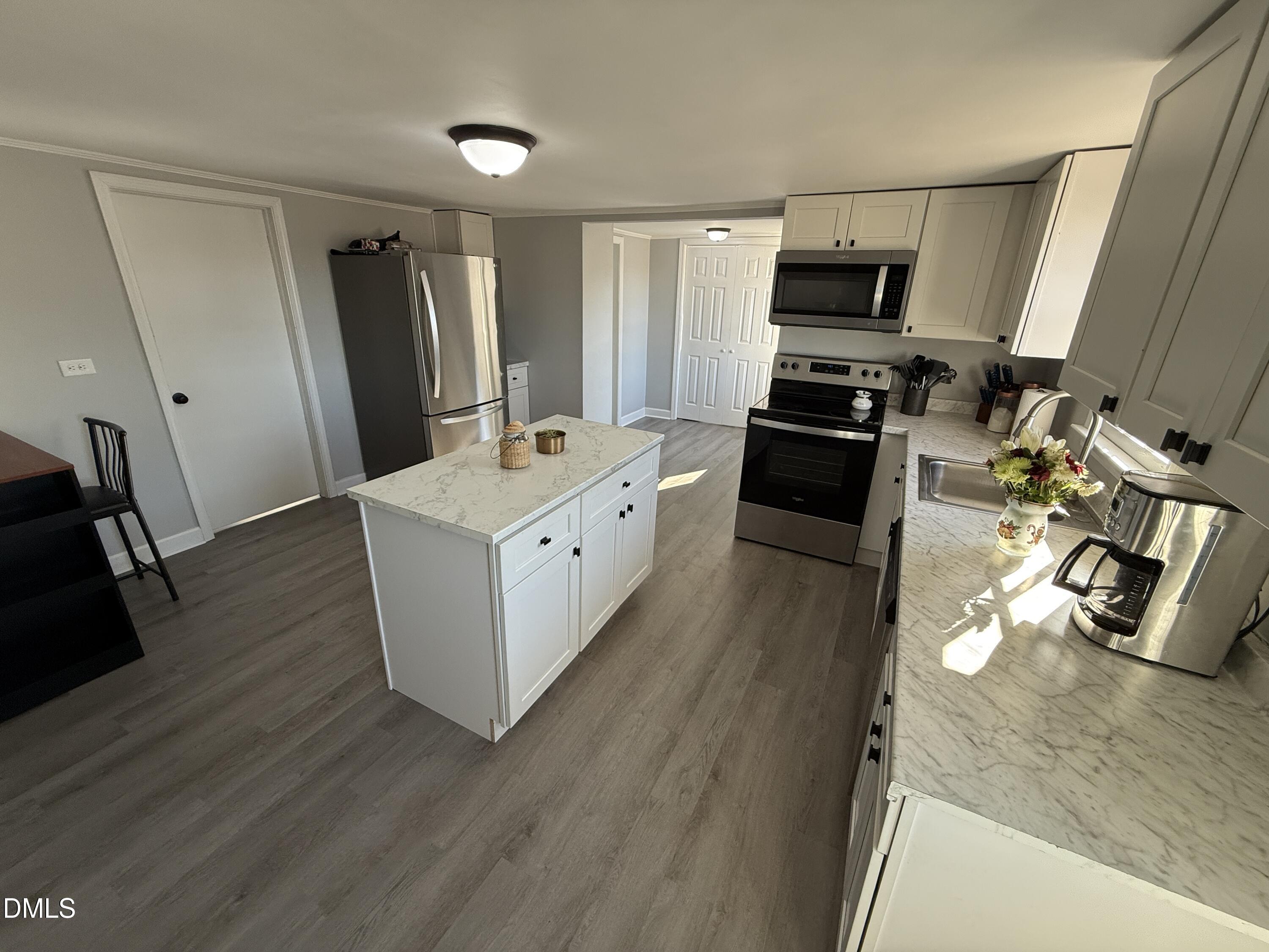 895 Stewart Road Four Oaks, NC 27524 - Photo 7 of 38 a kitchen with stainless steel appliances a refrigerator sink and stove