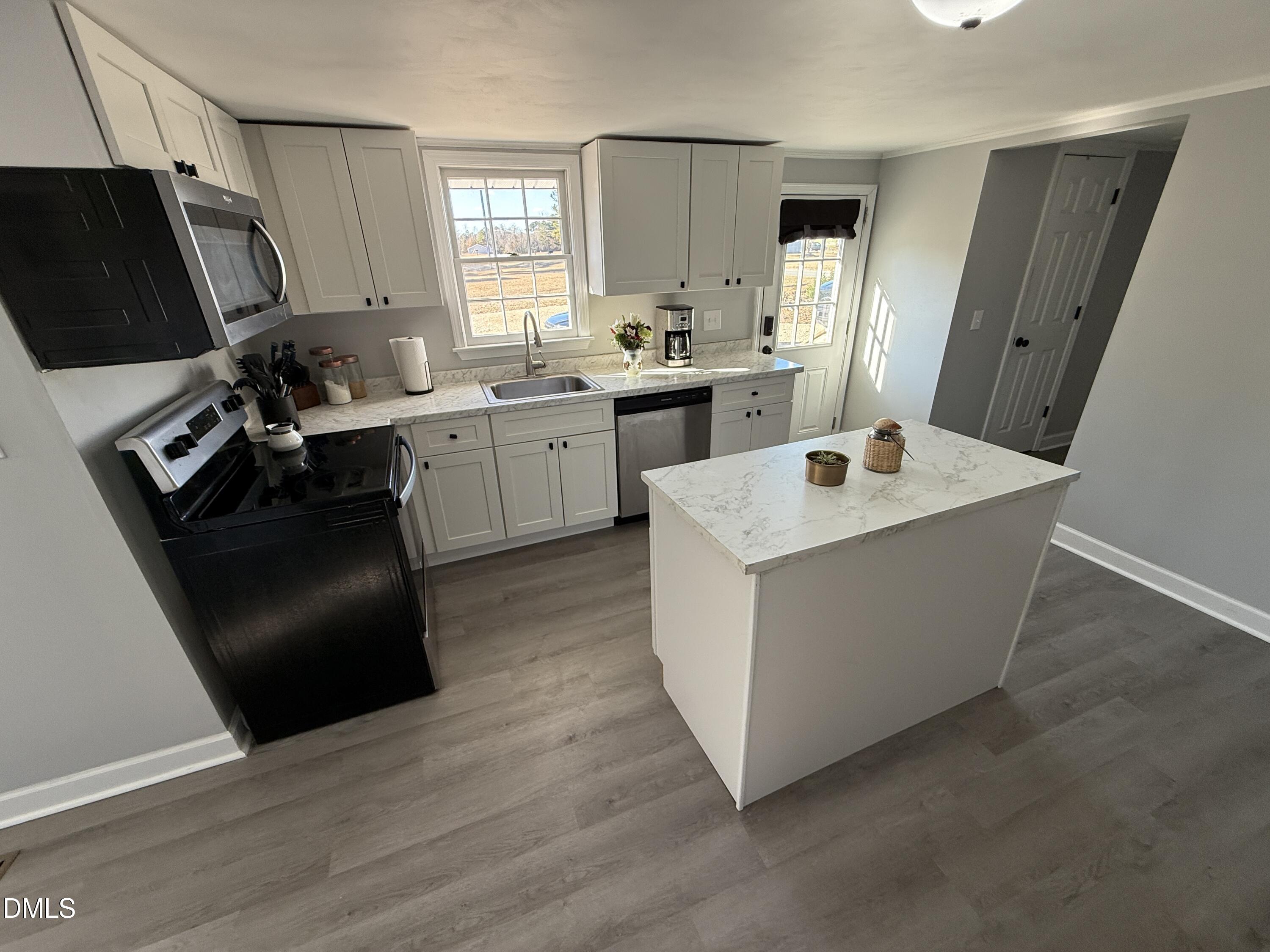 895 Stewart Road Four Oaks, NC 27524 - Photo 8 of 38 a kitchen with a sink stove and refrigerator
