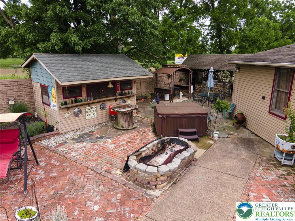 2485 Hieter Road Quakertown, PA 18951 - Photo 80 of 97 A private backyard oasis features a cozy shed bar, a relaxing spa, and a stone fire pit, perfect for entertaining.