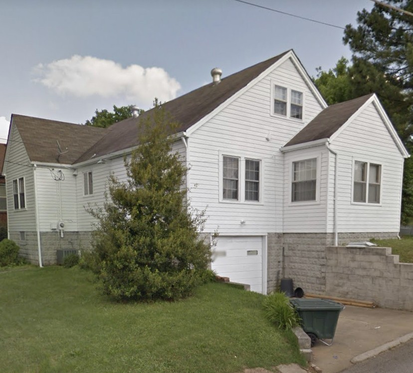 a view of a white house next to a yard
