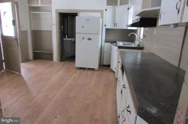 a kitchen with a sink a refrigerator and cabinets