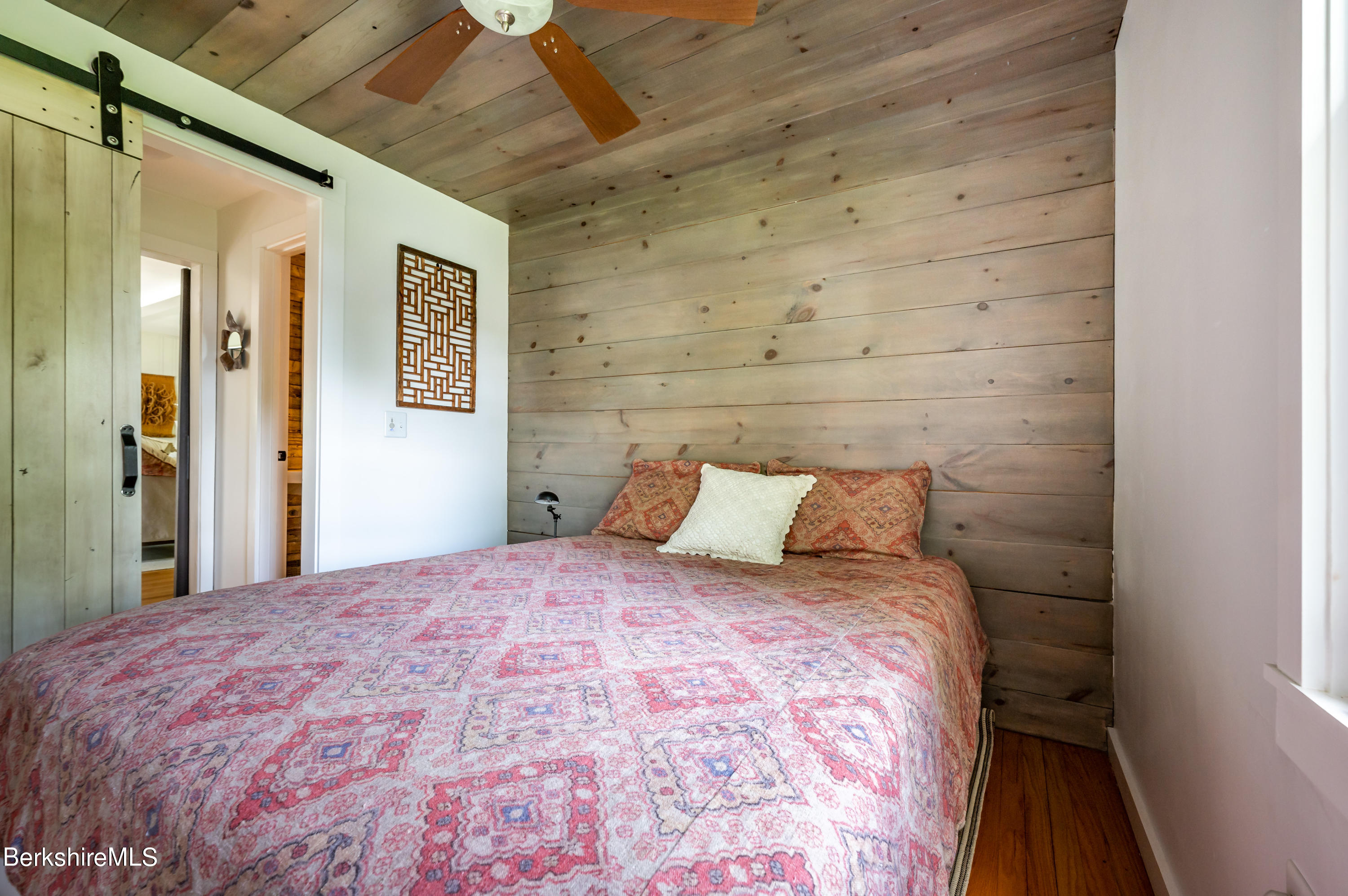 219 Shore Road Richmond, MA 01201 - Photo 14 of 28 a large bed in a bedroom next to a window