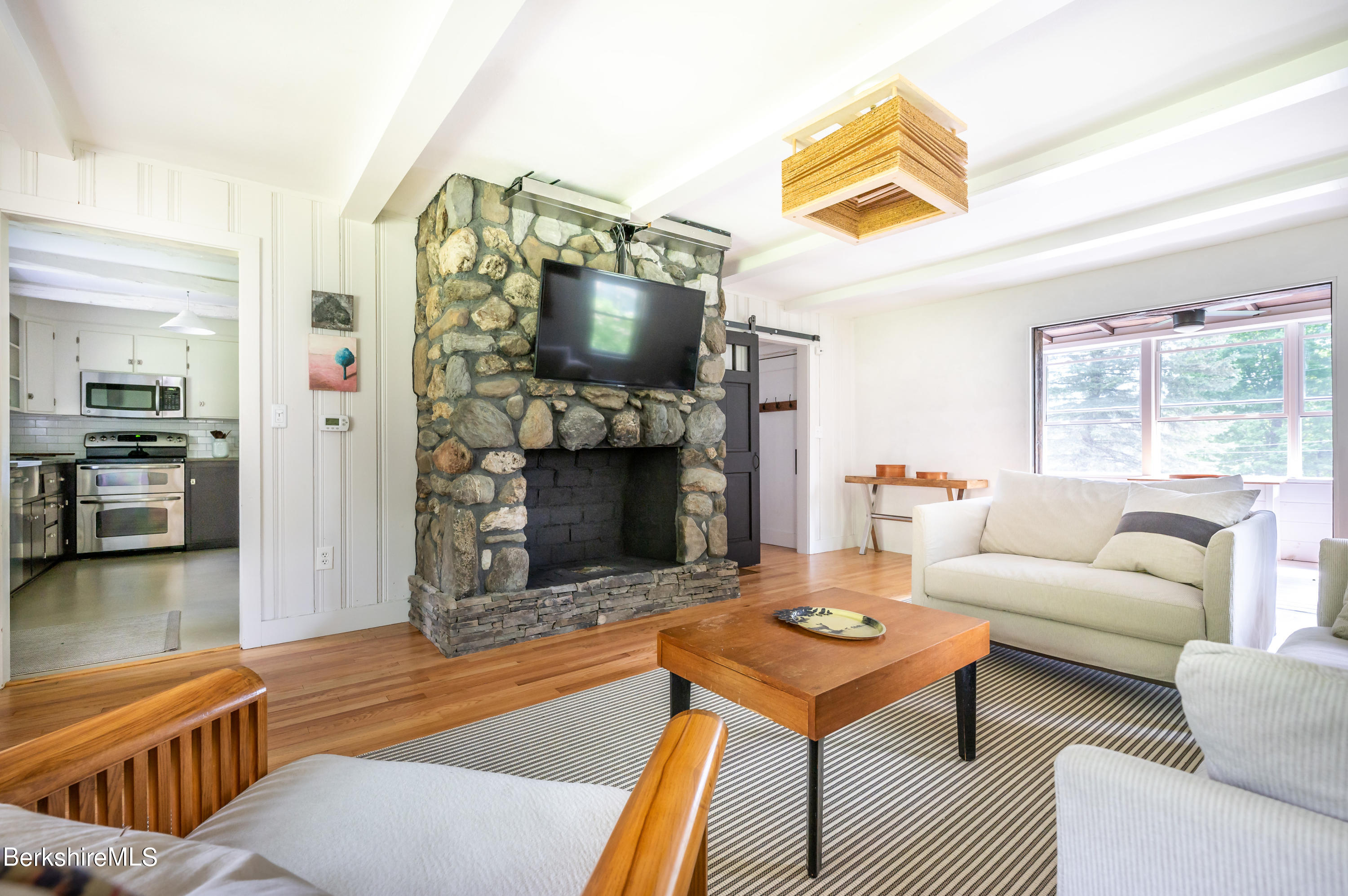 219 Shore Road Richmond, MA 01201 - Photo 6 of 28 a living room with furniture a flat screen tv and a fireplace