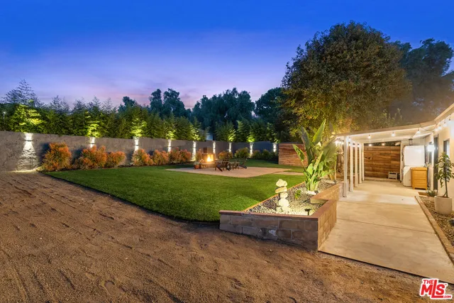 a view of a chairs and table in backyard of the house