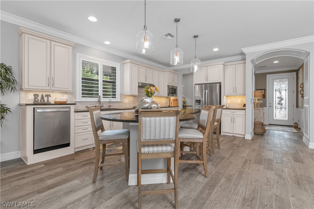 10832 Dennington Road Fort Myers, FL 33913 - Photo 3 of 34 a kitchen with a dining table chairs refrigerator and cabinets