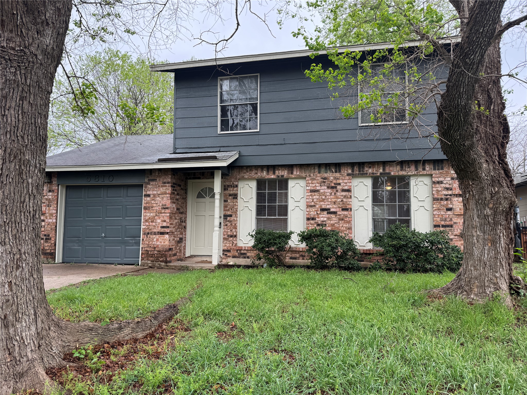 5810 Hammermill Run Austin, TX 78744 - Photo 2 of 10 View of front of home with brick siding, a garage, a front lawn, and concrete driveway