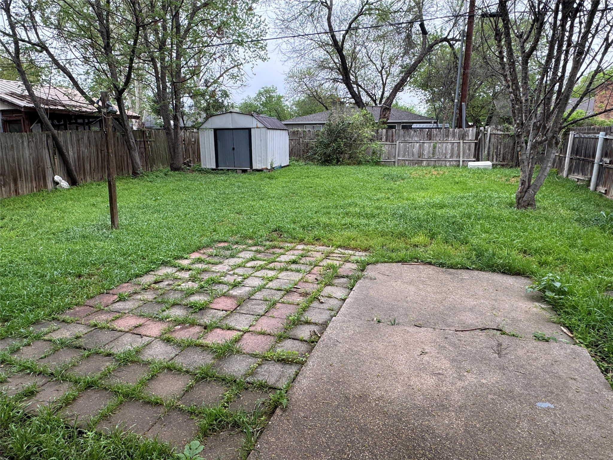 5810 Hammermill Run Austin, TX 78744 - Photo 6 of 10 View of yard featuring an outbuilding, a patio area, a fenced backyard, and a shed