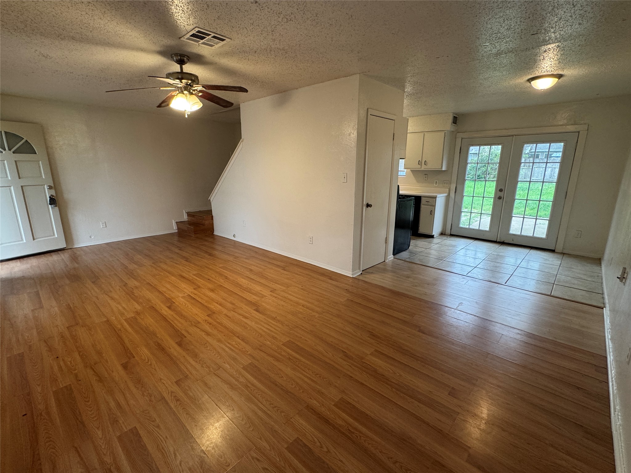 5810 Hammermill Run Austin, TX 78744 - Photo 8 of 10 Unfurnished living room featuring ceiling fan, a textured ceiling, light wood finished floors, and visible vents