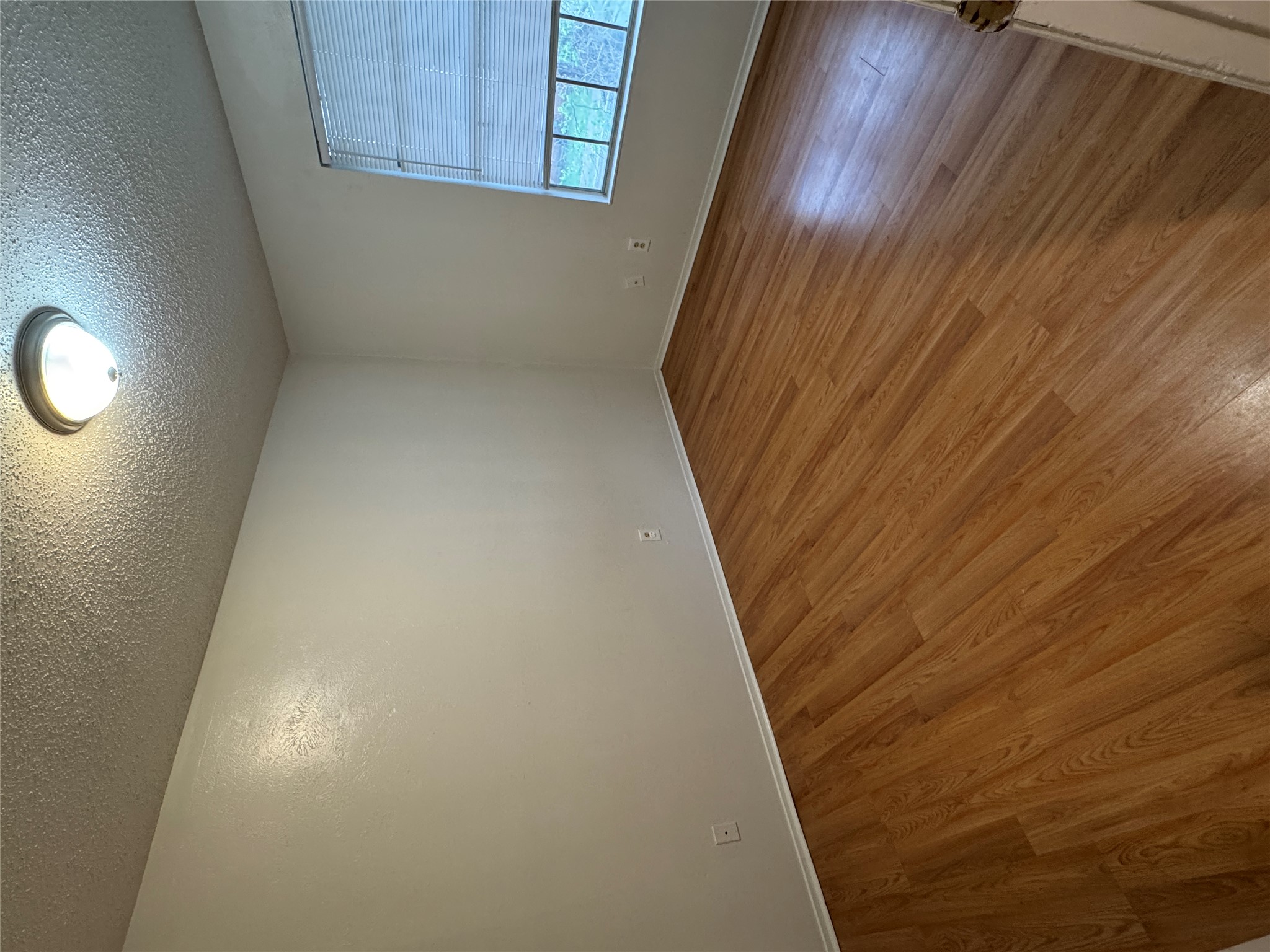 5810 Hammermill Run Austin, TX 78744 - Photo 9 of 10 Empty room with a textured ceiling, baseboards, and wood finished floors