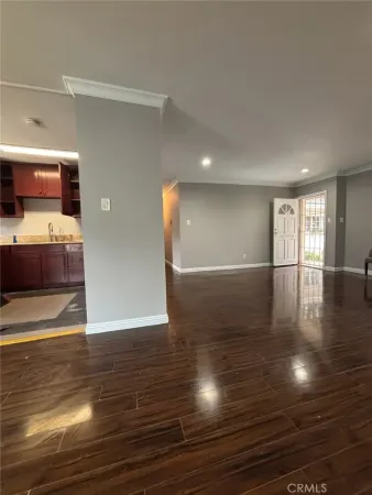 a view of empty room with wooden floor