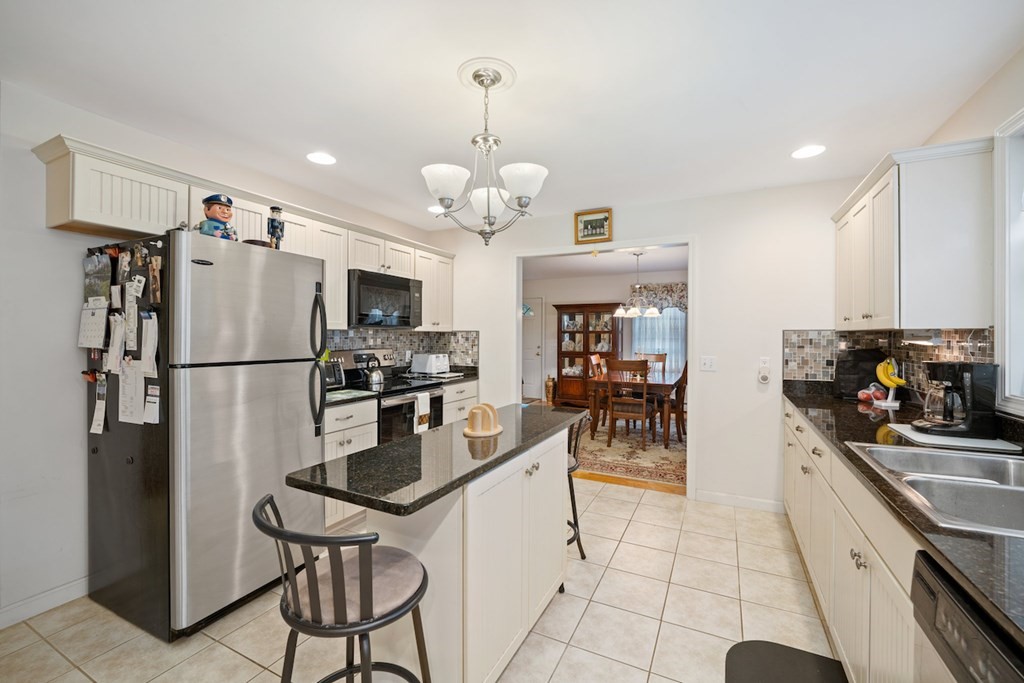 90 Greenwich Road Ware, MA 01082 - Photo 11 of 41 a kitchen with stainless steel appliances granite countertop a refrigerator a sink a stove a dining table and chairs with wooden floor