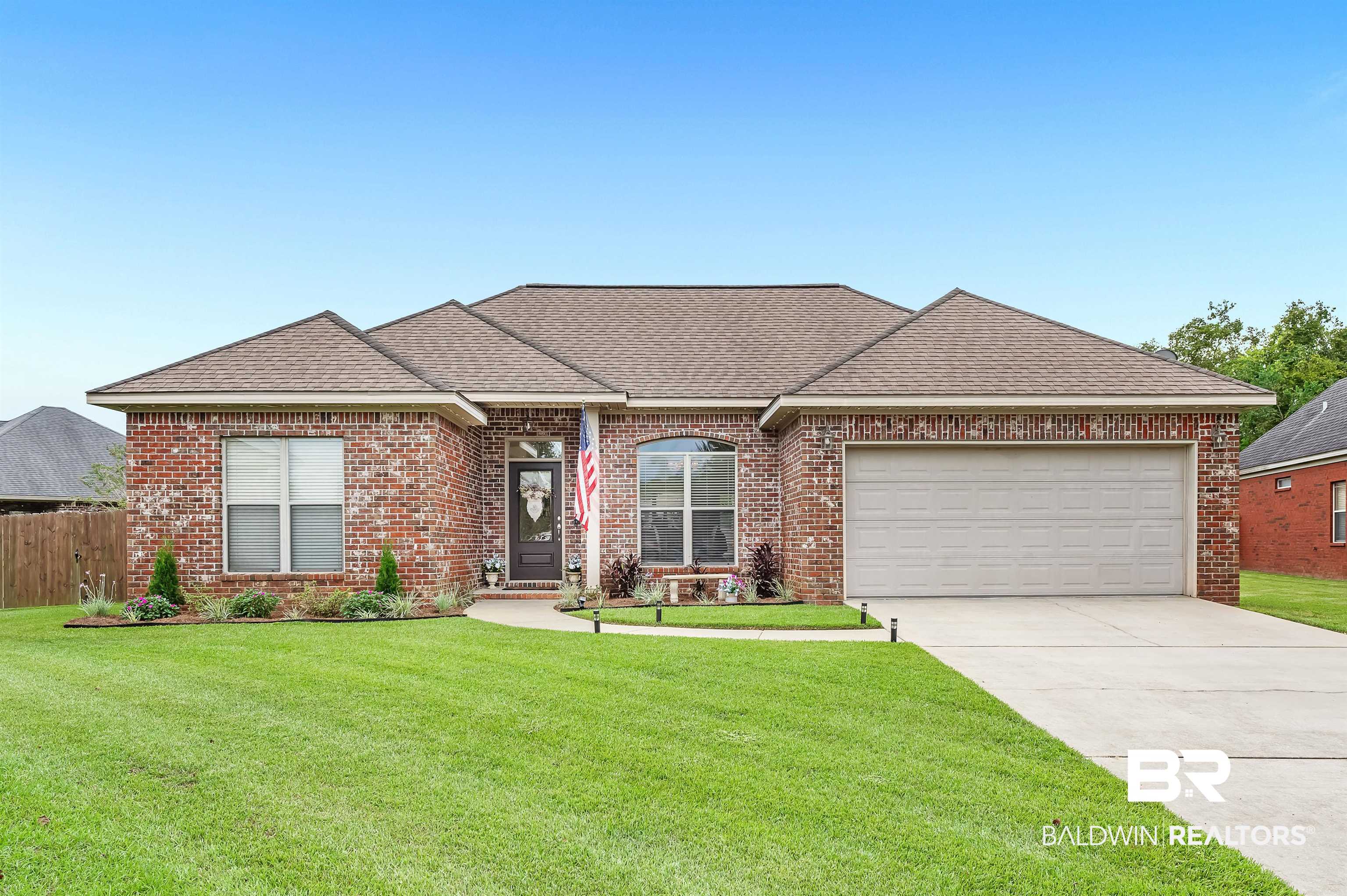 Ranch-style house featuring a garage and a front yard
