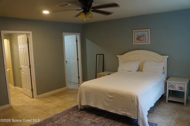 a bedroom with a bed and a ceiling fan