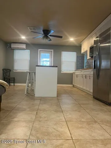 a view of a kitchen with furniture and a refrigerator