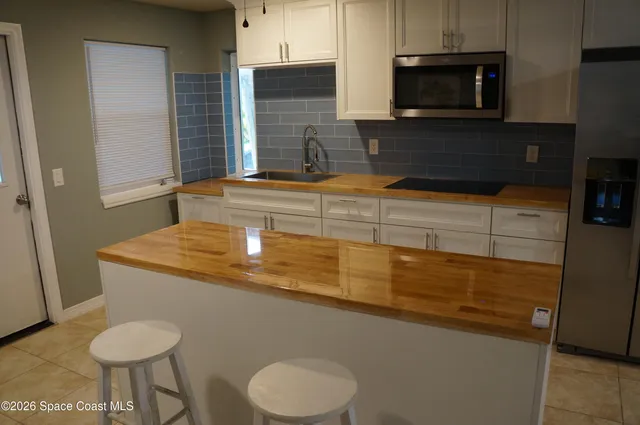a kitchen with stainless steel appliances granite countertop a sink and a microwave