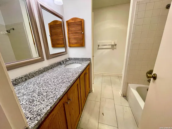 a bathroom with a granite countertop sink and a mirror