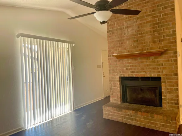 a living room with a fireplace and a ceiling fan