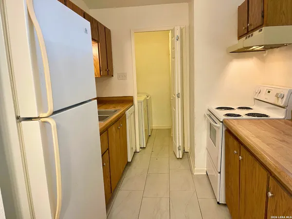 a utility room with cabinets washer and dryer