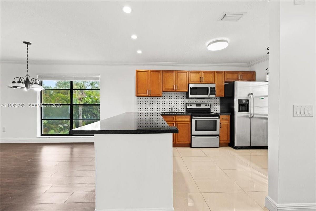 7944 Eastlake Drive, Unit D Boca Raton, FL 33433 - Photo 5 of 29 a kitchen with stainless steel appliances a refrigerator and a stove top oven