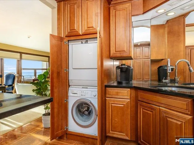 a kitchen with stainless steel appliances granite countertop a refrigerator a sink and white cabinets