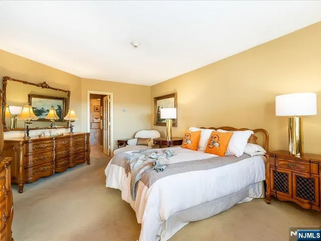 a bedroom with a bed and dresser with mirror