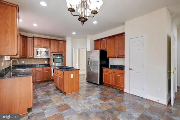 a kitchen with stainless steel appliances granite countertop a stove a refrigerator and a sink