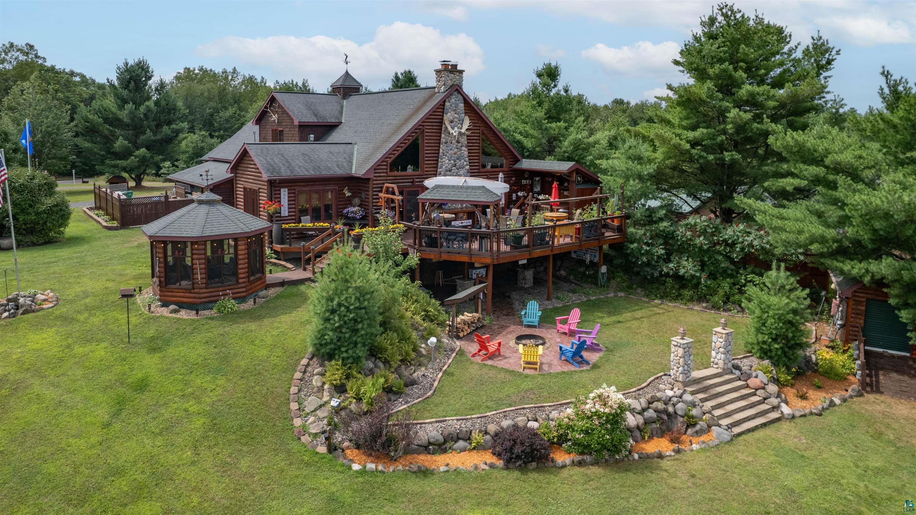 11911 East Rowe Road Lake Nebagamon, WI 54849 - Photo 2 of 61 Log cabin-style residence featuring a multi-level deck, a screened gazebo, and a stone staircase