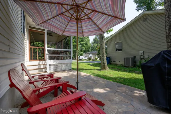 a view of a patio with table and chairs under an umbrella