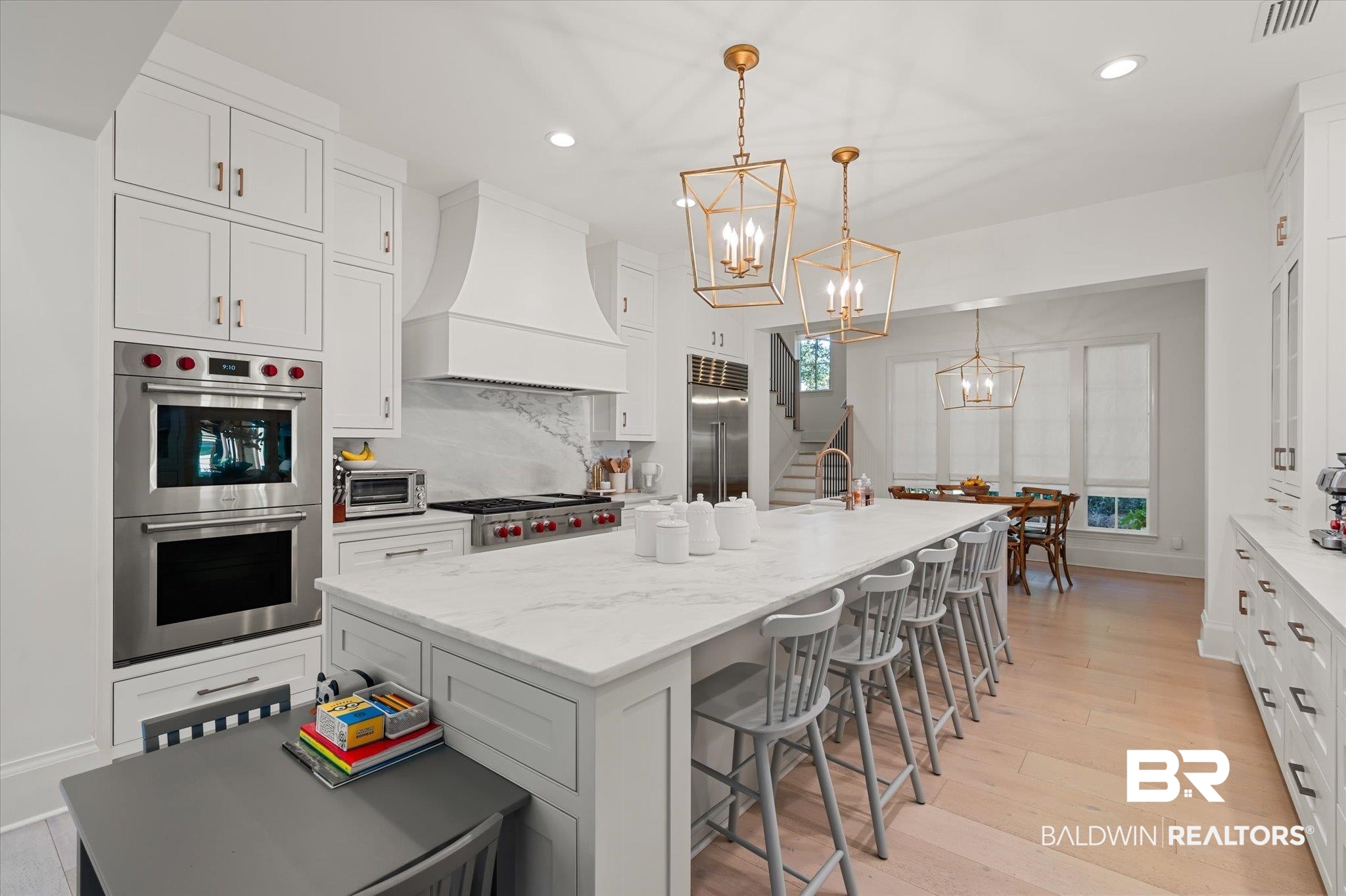 2 Garden Trace Mobile, AL 36608 - Photo 5 of 55 Kitchen with appliances with stainless steel finishes, decorative light fixtures, white cabinets, a kitchen island with sink, and custom range hood