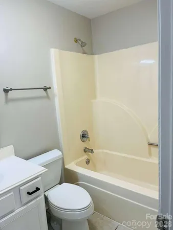 a white toilet and tub sitting next to a bathroom sink